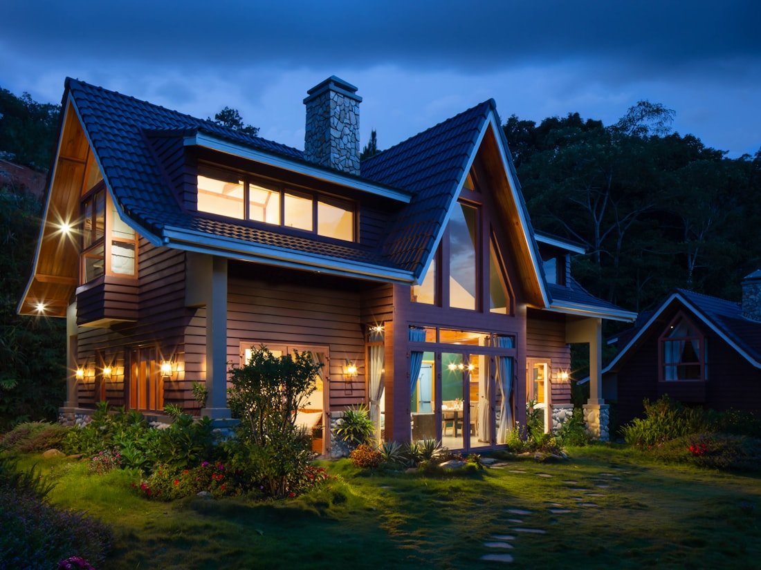 Ottawa home addition exterior at twilight with stone chimney and warm interior light